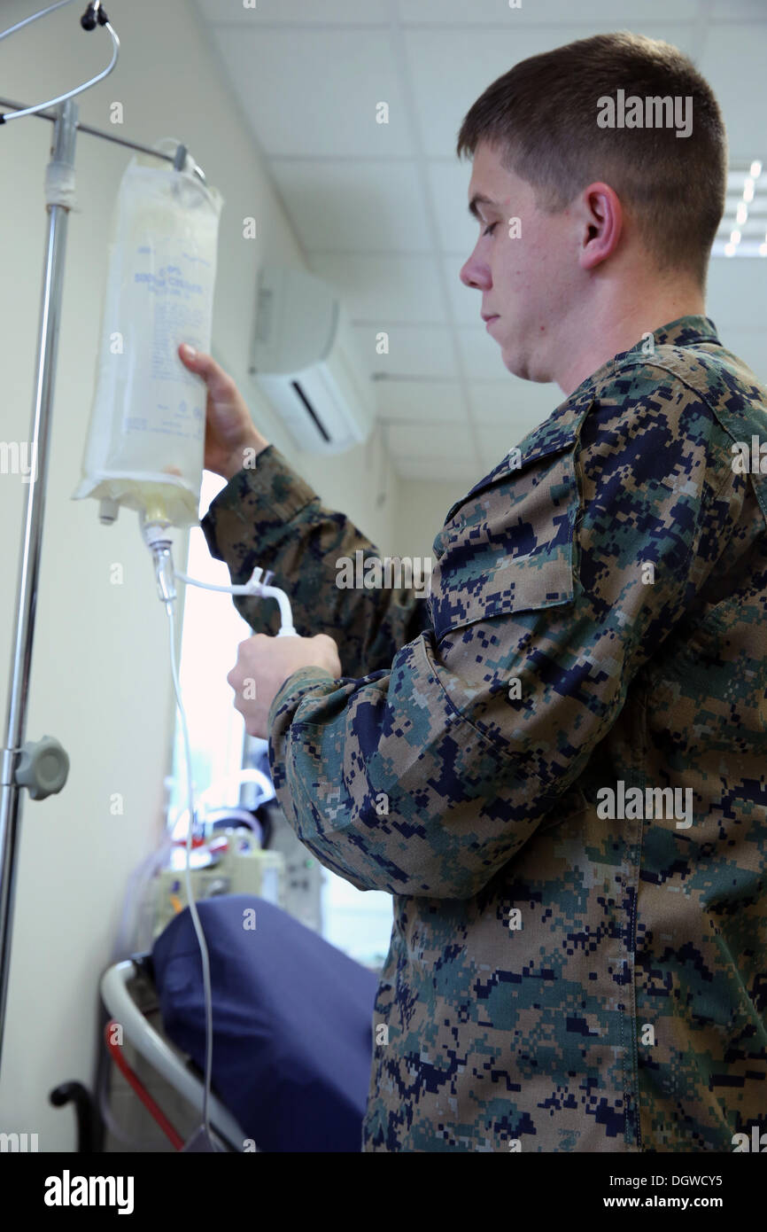 La troisième classe Boeji Hospitalman Michael, une mer Noire avec corpsman Force de rotation 14, prépare un sac de liquide intraveineux IV la formation au poste de secours du bataillon de Mihail Kogalniceanu, Roumanie, 18 oct., 2013. Boeji fut choisi pour Marine de la semaine fo Banque D'Images