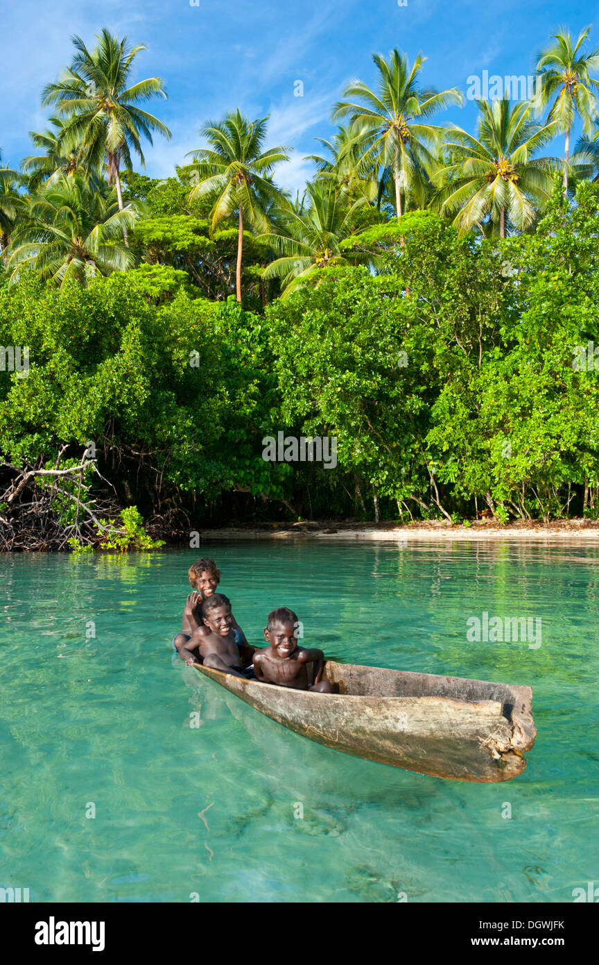 Les garçons locaux dans un canot dans le lagon de Marovo Lagon de Marovo,, Province de l'Ouest, les Îles Salomon Banque D'Images