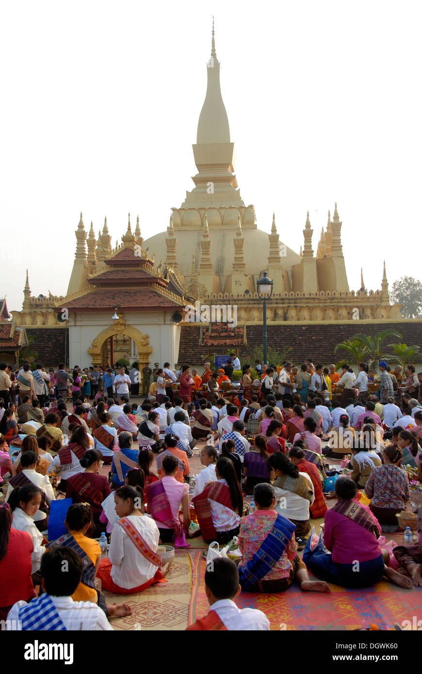 Le bouddhisme Theravada, That Luang Festival, Tak Bat, les croyants, les pèlerins assis sur le sol, priant devant la pha Banque D'Images