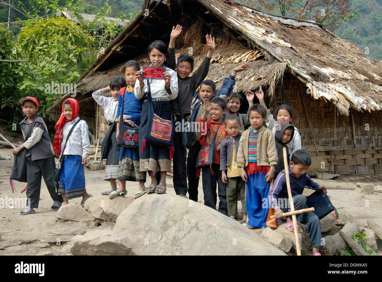 La pauvreté, les enfants heureux dans un village en face d'une simple hutte, groupe ethnique akha Oma, Sala Abe, province de Phongsali, Laos Banque D'Images