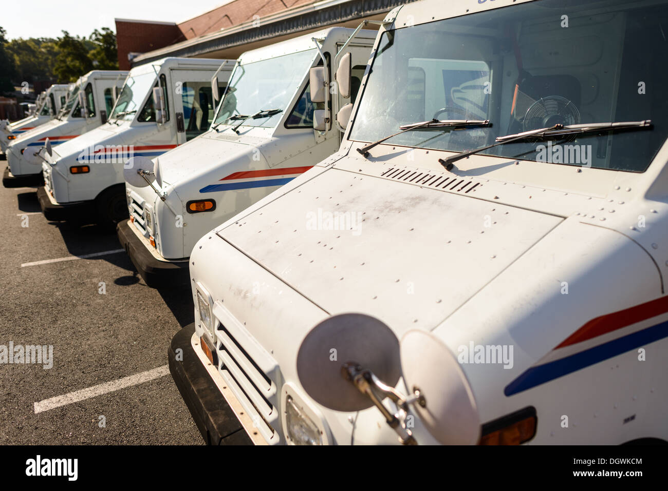 United States postal Service Trucks stationnés États-Unis // ÉTATS-UNIS - Une rangée soignée de camions blancs emblématiques United States postal Service se trouve stationnés à l'extérieur d'un bureau de poste, leur logo distinctif bleu aigle clairement visible. Cette scène capture l'essence du vaste réseau de livraison de l'USPS, mettant en valeur les véhicules qui jouent un rôle crucial dans la connexion des communautés à travers l'Amérique par le service de courrier. Banque D'Images