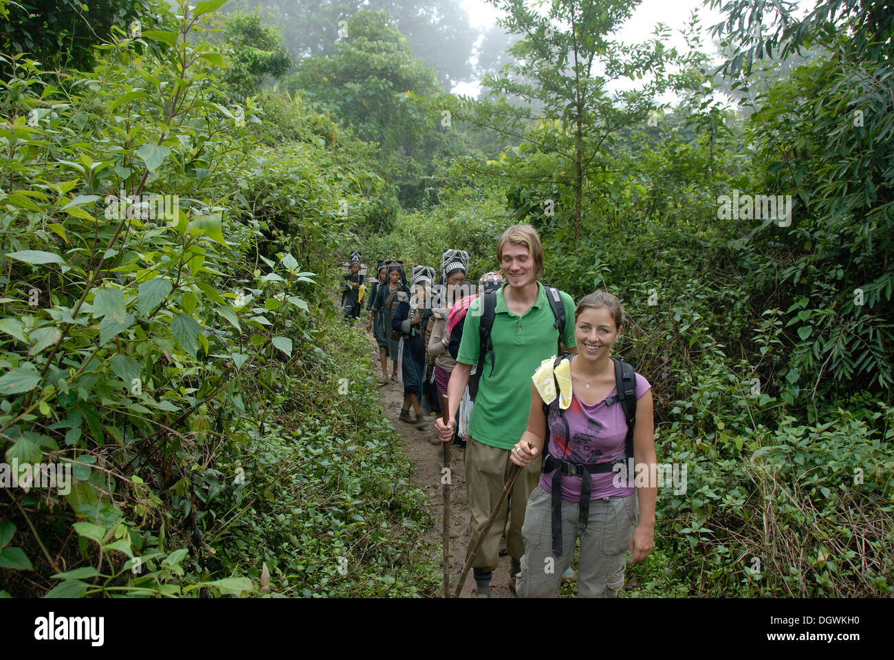 Trekking, smiling touristes occidentaux avec les femmes de l'ethnie Akha Nuqui, jungle track à Ban Phou Yot Banque D'Images