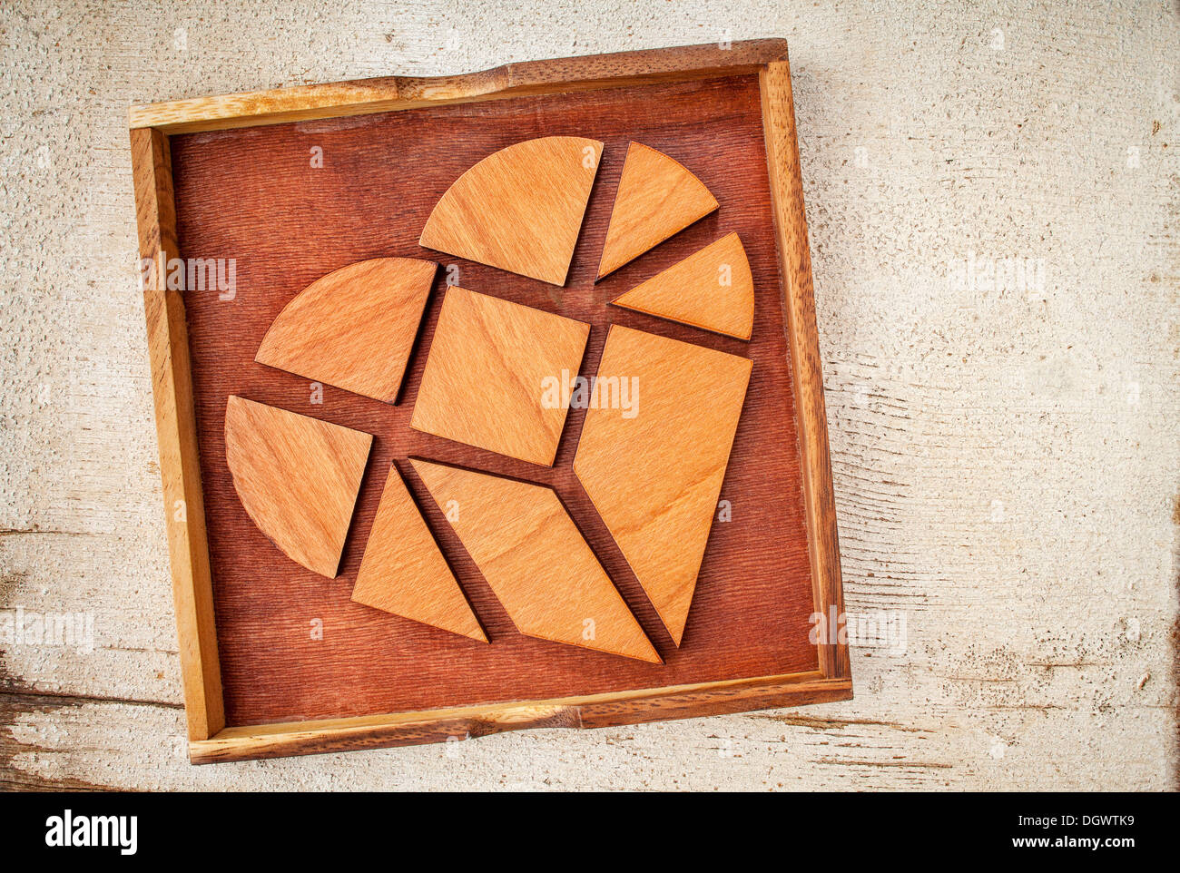 Cœur brisé - pièces tangram dans une boîte, un jeu de puzzle chinois traditionnels faits de bois différentes pièces pour construire des figures abstraites Banque D'Images