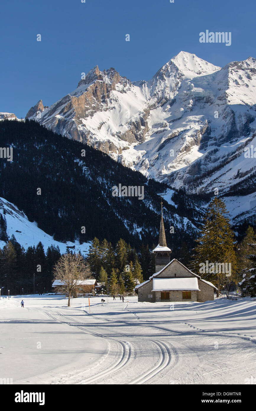 Paysage d'hiver avec les skieurs de fond, Blueemlisalp massif au milieu, Eglise St Mary, Alpes Bernoises, Kandersteg Banque D'Images