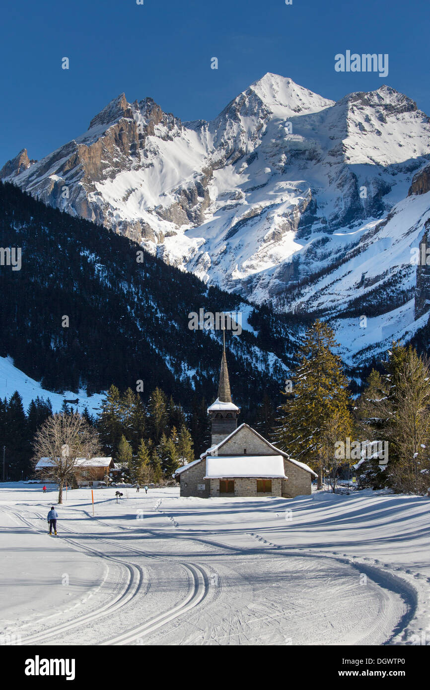 Paysage d'hiver avec les skieurs de fond, Blueemlisalp massif au milieu, Eglise St Mary, Alpes Bernoises, Kandersteg Banque D'Images