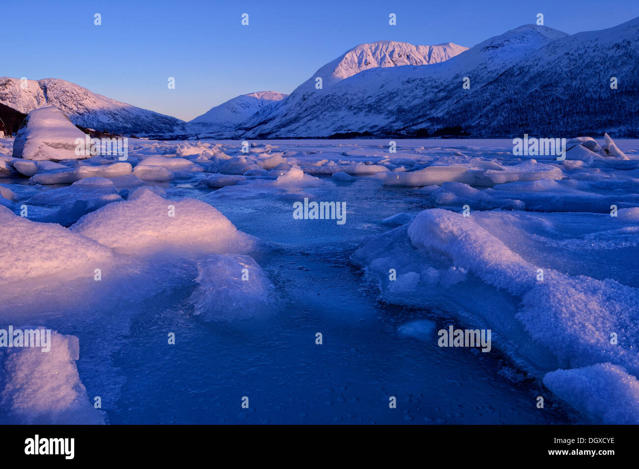 Fjord avec des pierres et des blocs de glace en face d'une chaîne de montagnes, Tromsø, ‪Troms, dans le Nord de la Norvège, la Norvège Banque D'Images