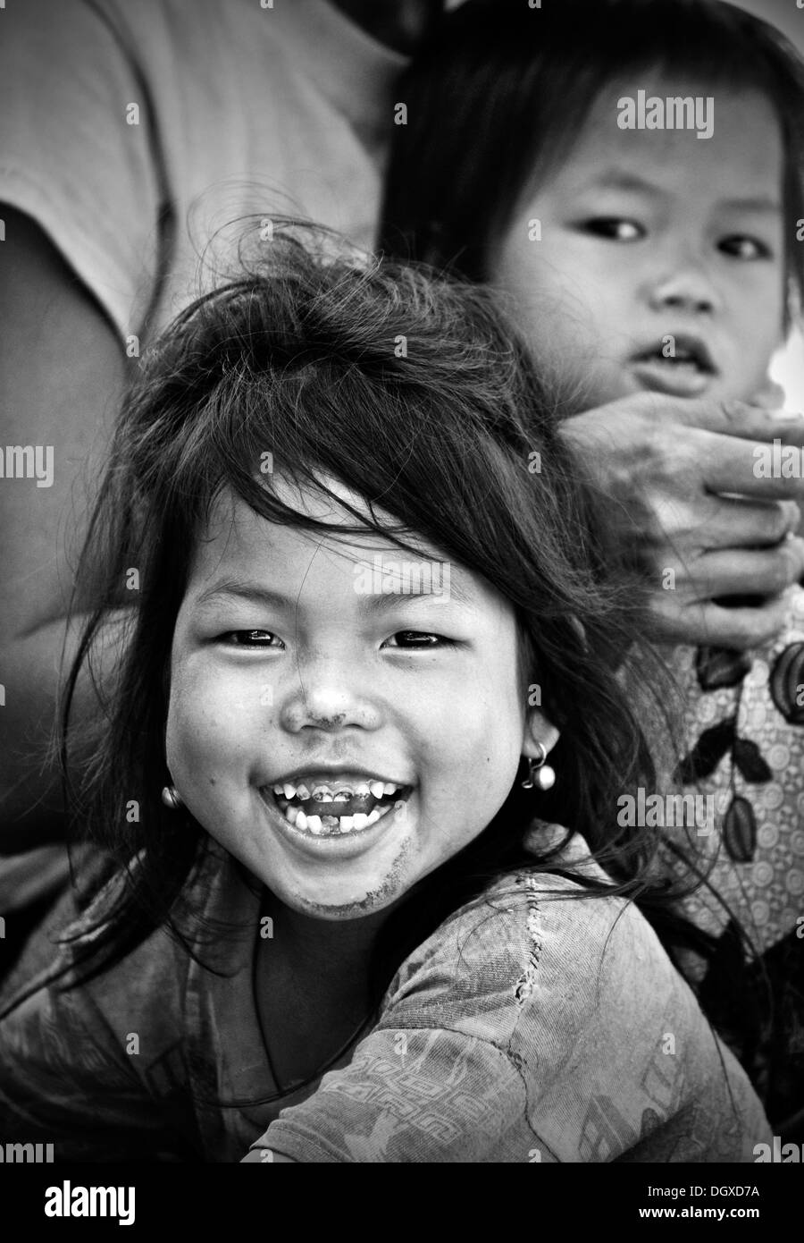 Smiling girl avec de mauvaises dents, un autre enfant à l'arrière, Laos, Asie du Sud, Asie Banque D'Images