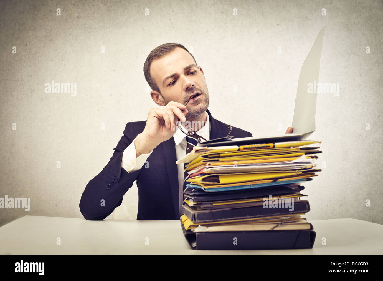 Jeune homme d'une pile de documents de lecture Banque D'Images