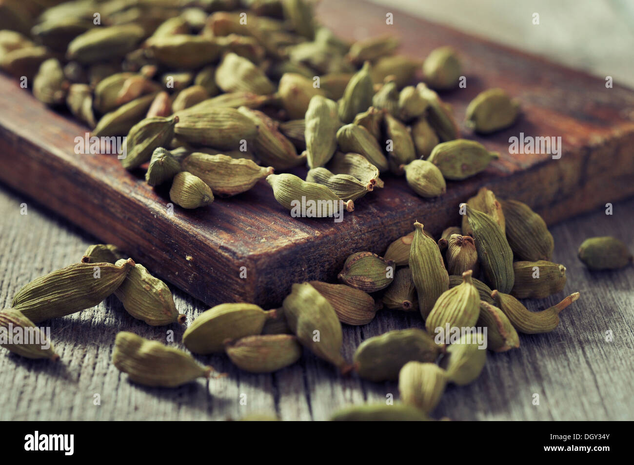 Les graines de cardamome à sec libre sur fond de bois Banque D'Images