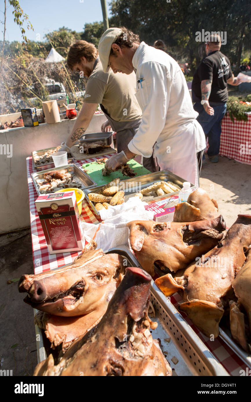 Chef irlandais J P McMahon, gauche, prépare un barbecue au cours de la cuisson du porc BBQ extérieur brut événement sur l'île de Bowen, 26 octobre 2013 à Charleston, SC. Banque D'Images