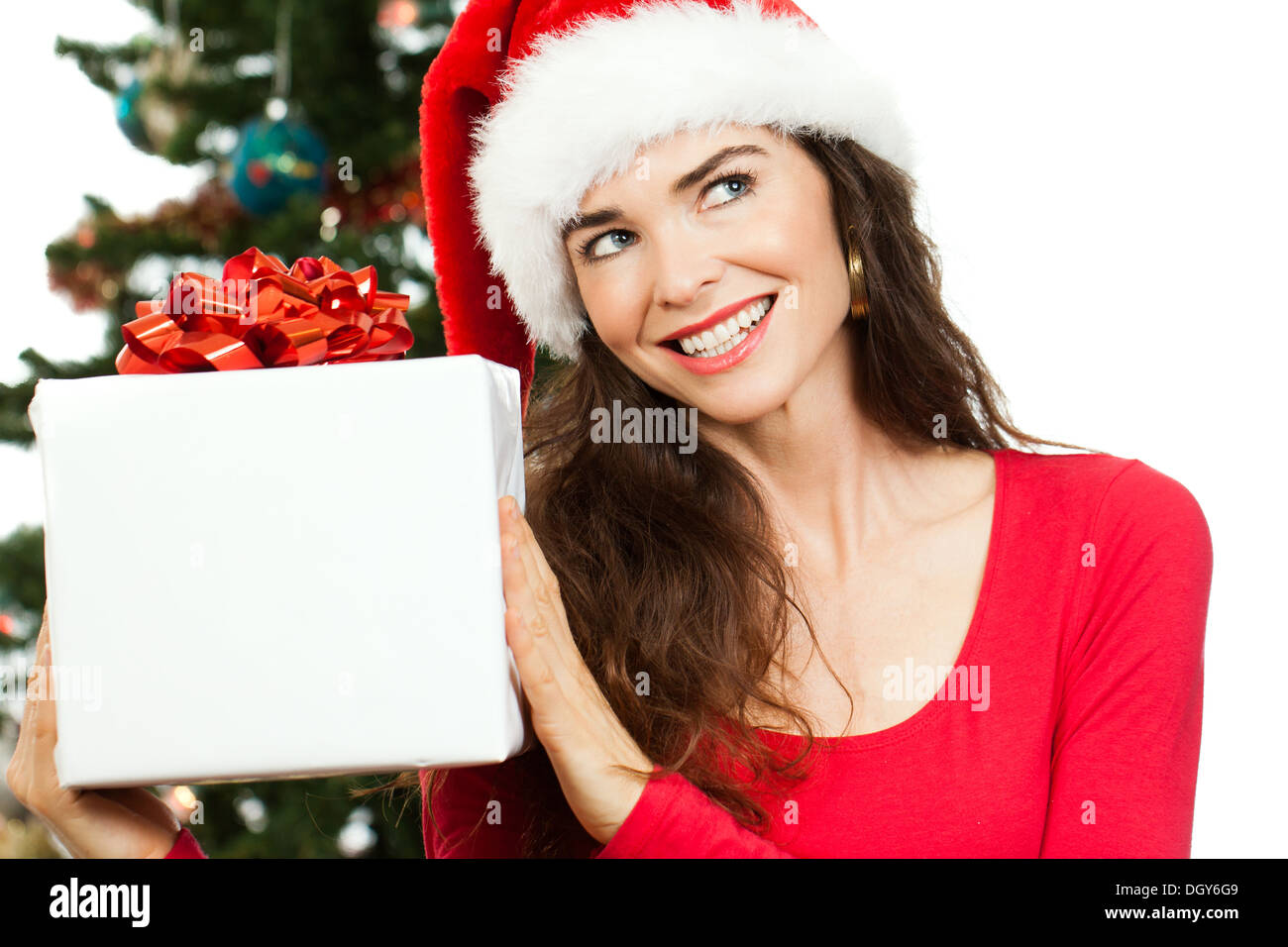 A smiling woman wearing a Santa hat and holding a big white cadeau de Noël et à la copie au-espace. Isolé sur w Banque D'Images