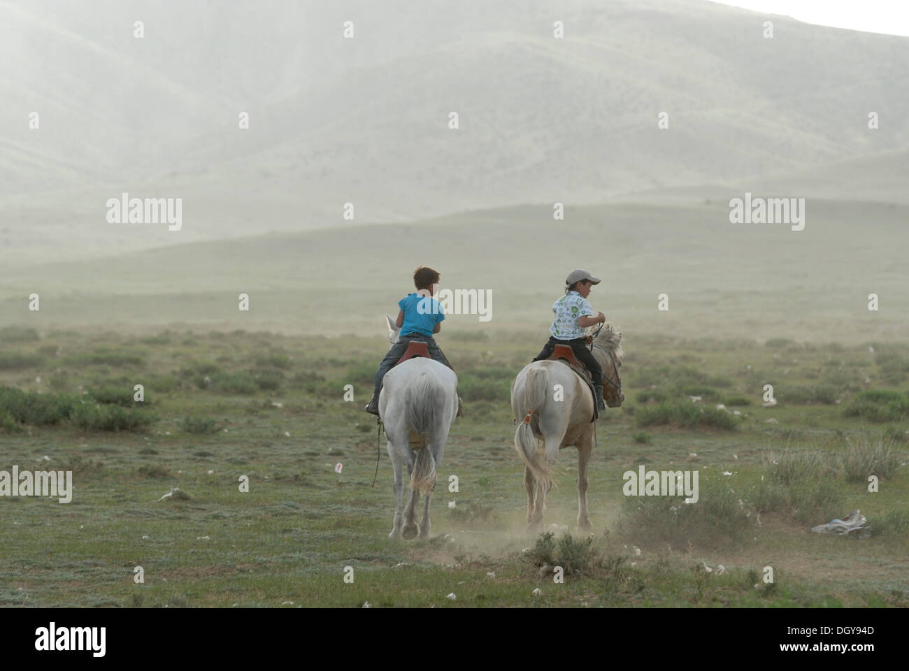 Deux petits enfants mongols, les garçons dans la circonscription de pelouses sèches sur les chevaux de Mongolie blanc, Lun, Toev Aimak, Mongolie, Asie Banque D'Images