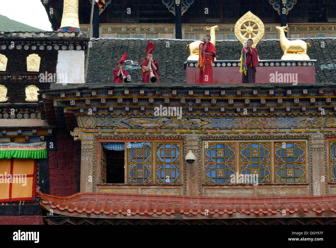 Moines avec peignoirs et moine moine rouge appelant caps à la prière avec une coquille de conque corne et de la trompette sur le toit-terrasse de la Banque D'Images