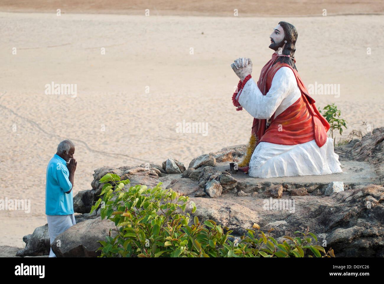 Orant debout devant la statue de Jésus Christ, Chowara beach, côte de Malabar, en Inde du Sud, Inde, Asie Banque D'Images