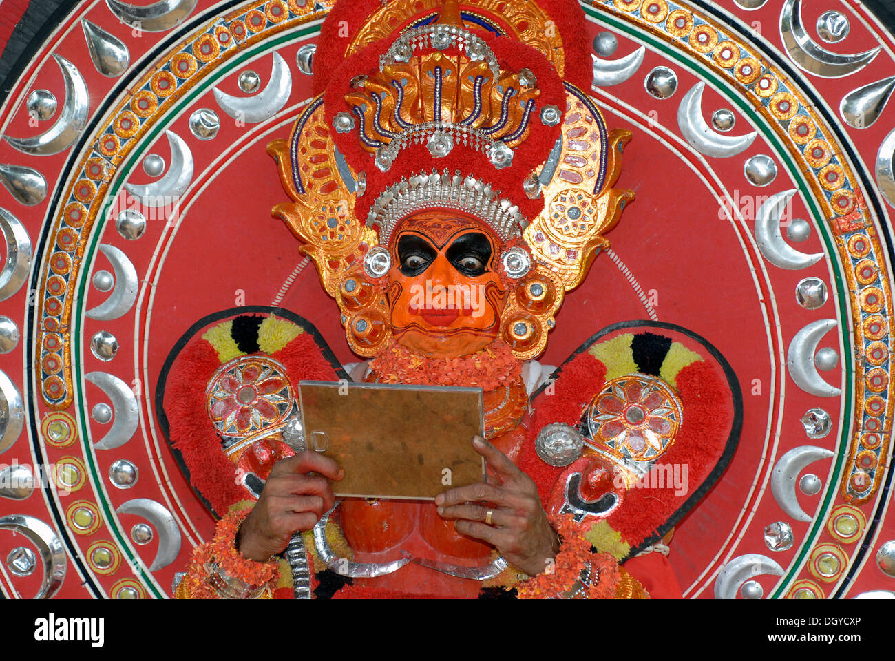 Artiste Theyyam à dans un miroir, moment de l'initiation, au cours d'un rituel Theyyam, près de Kasargod, Kerala, Inde du Sud au Nord Banque D'Images