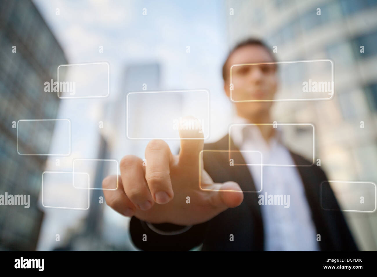 En poussant à la main sur une interface d'écran tactile sur des immeubles commerciaux Contexte Banque D'Images