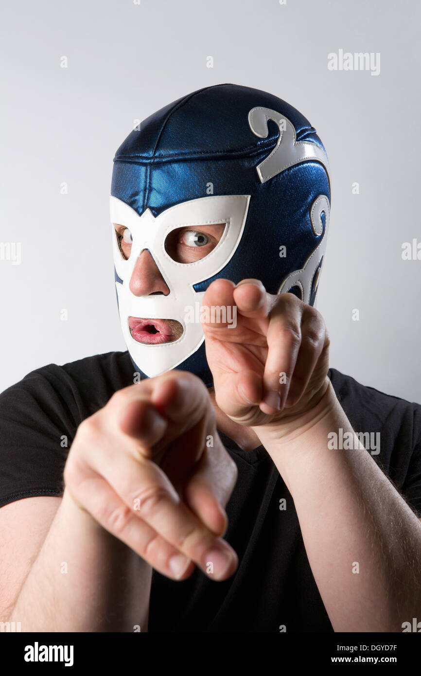 Un homme portant un masque de catch Lucha Libre et gesticulant bizarrement avec ses mains Banque D'Images