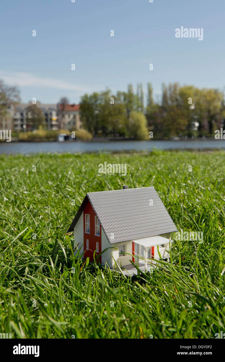 Une maison miniature sur la pelouse près de la rive d'une rivière Banque D'Images