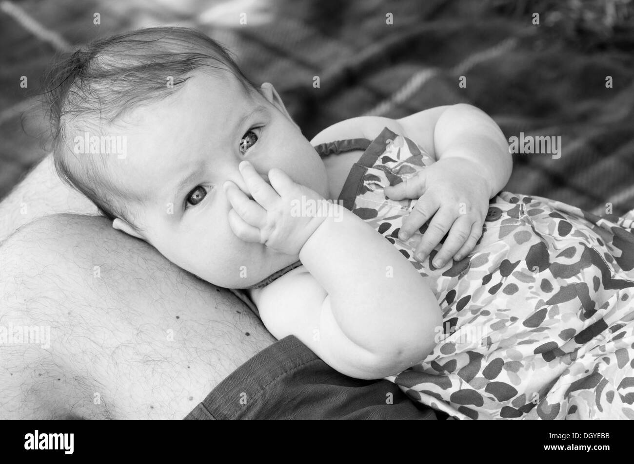 Close up noir et blanc portrait de petite fille sucer son pouce Banque D'Images