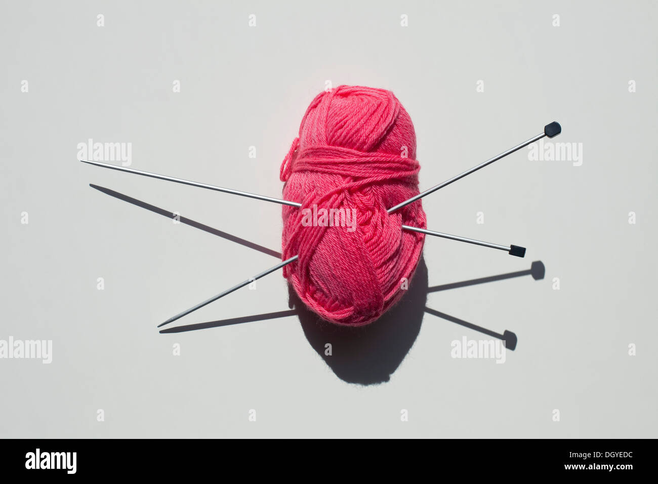 Une paire d'aiguilles à tricoter coincé dans une pelote de laine Banque D'Images