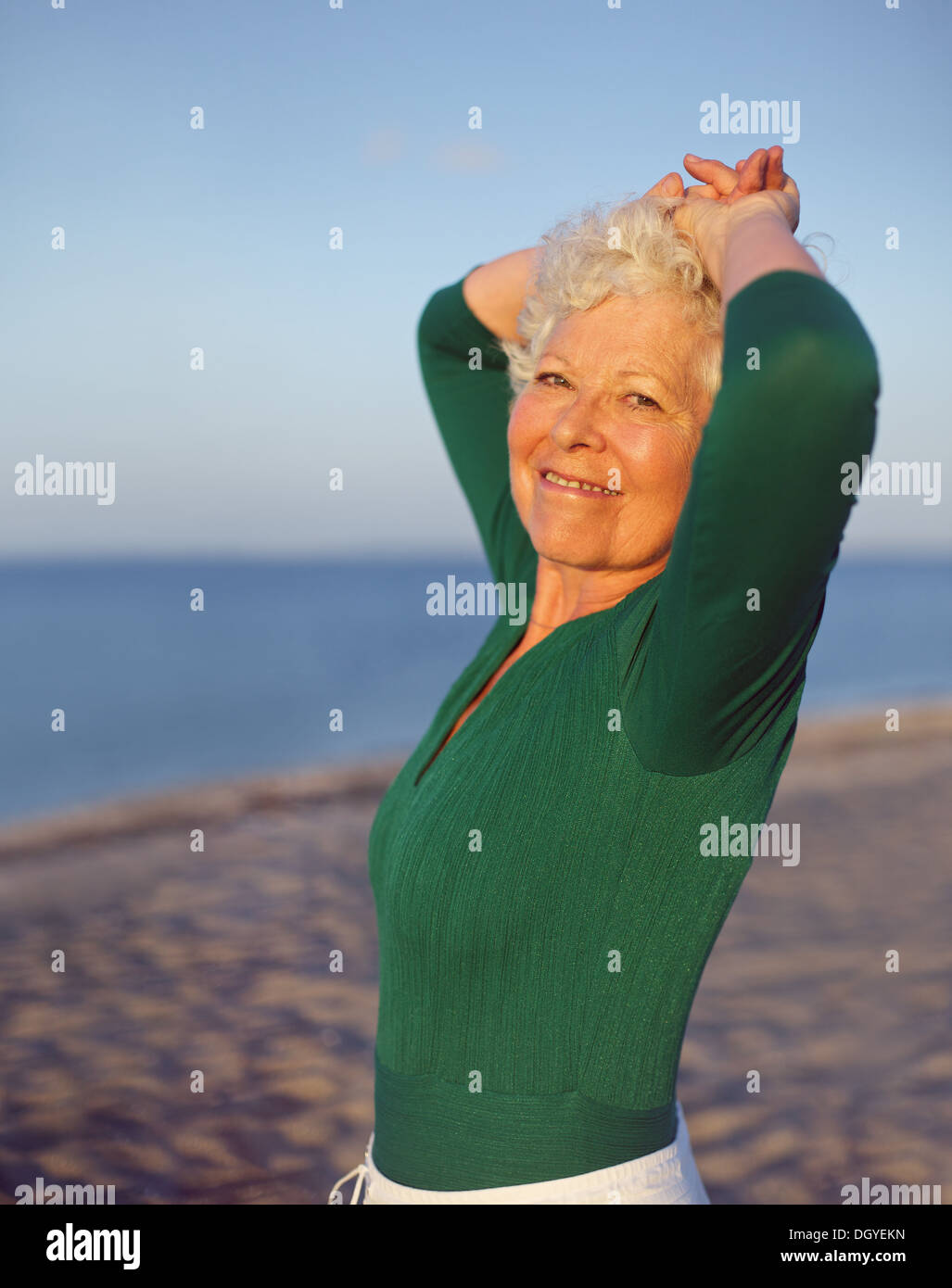 Portrait of senior woman standing belle ambiance sur la plage avec l'océan et le ciel comme arrière-plan flou et copiez l'espace. Banque D'Images