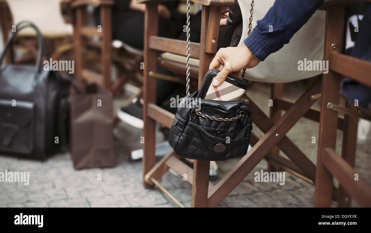 En prenant l'homme portefeuille d'une femme à la Bourse du café de la rue pendant la journée. Vol de sac à main. voleur La tire au café de la rue Banque D'Images