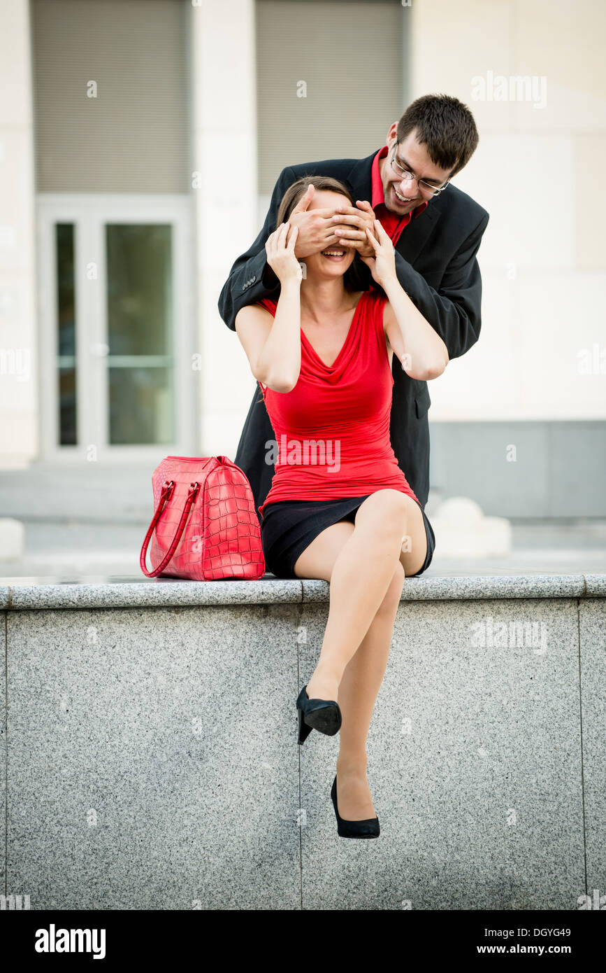 Jeune homme d'affaires en attente de surprises en couvrant ses yeux femme Banque D'Images
