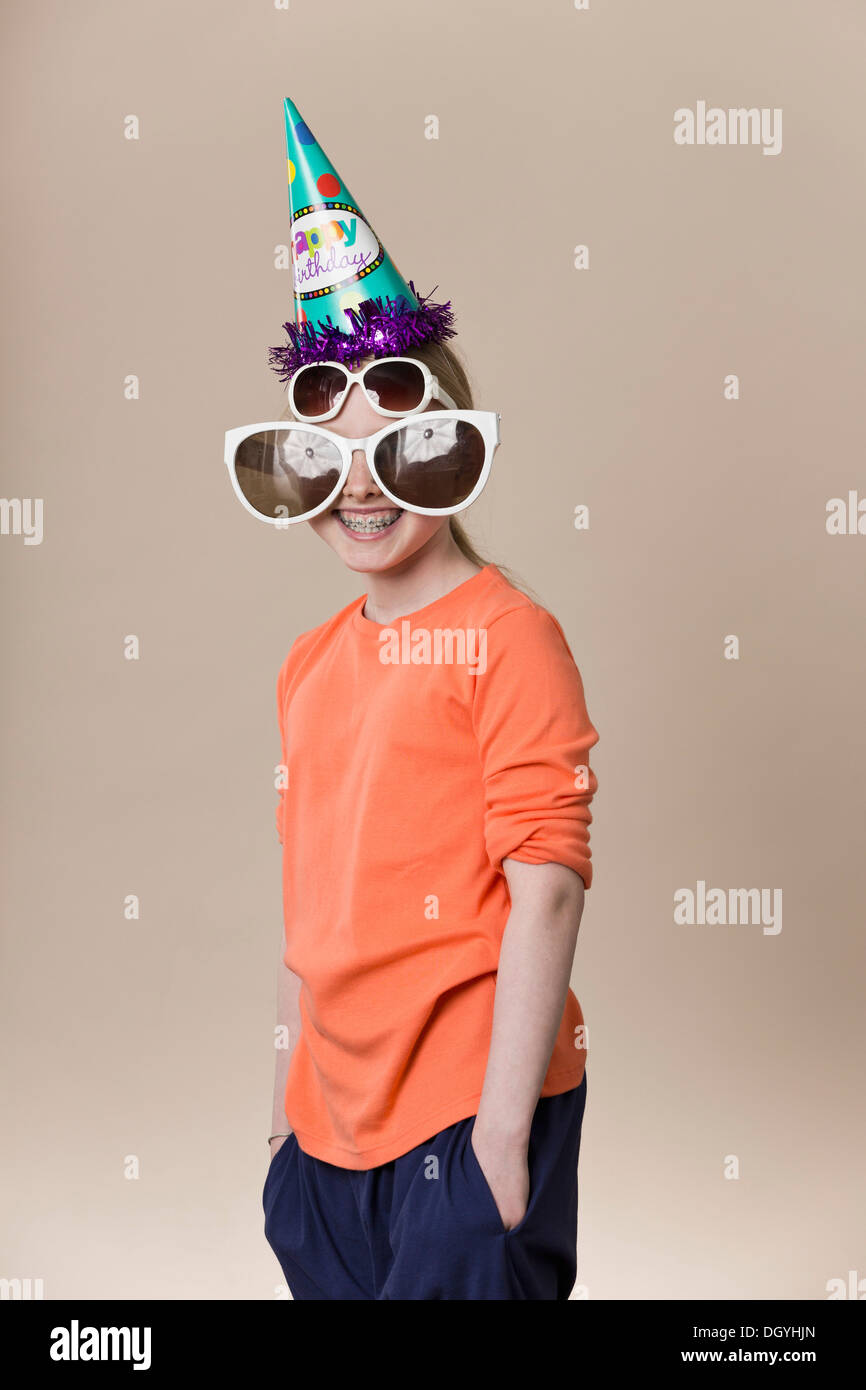 Une jeune fille portant une paire de lunettes de grande nouveauté, une paire de lunettes et d'un party hat Banque D'Images