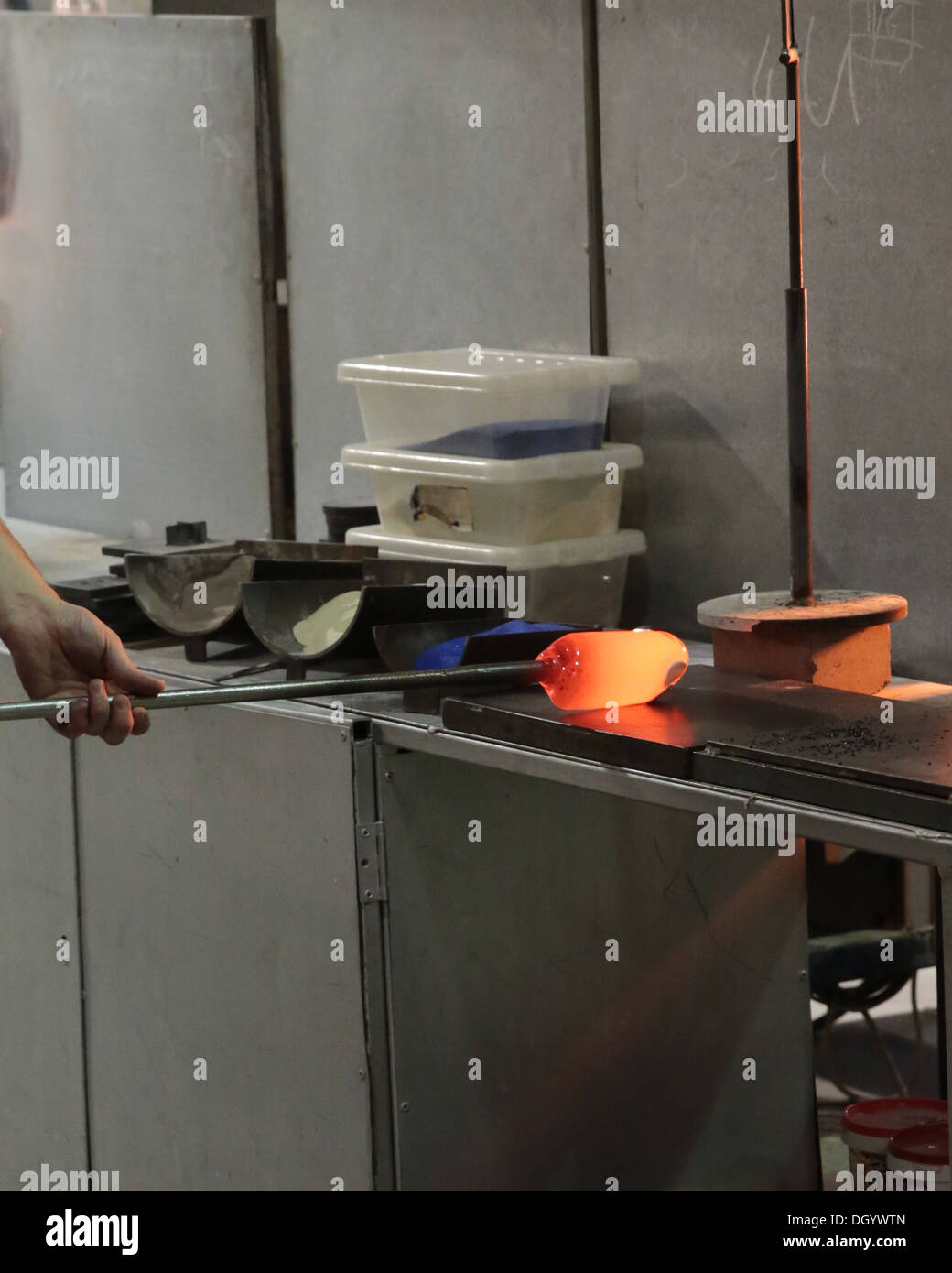 La fabrication du verre des presse-papiers en utilisant la plaque d'acier, ou marver, pour rendre le verre fondu circulaire Banque D'Images