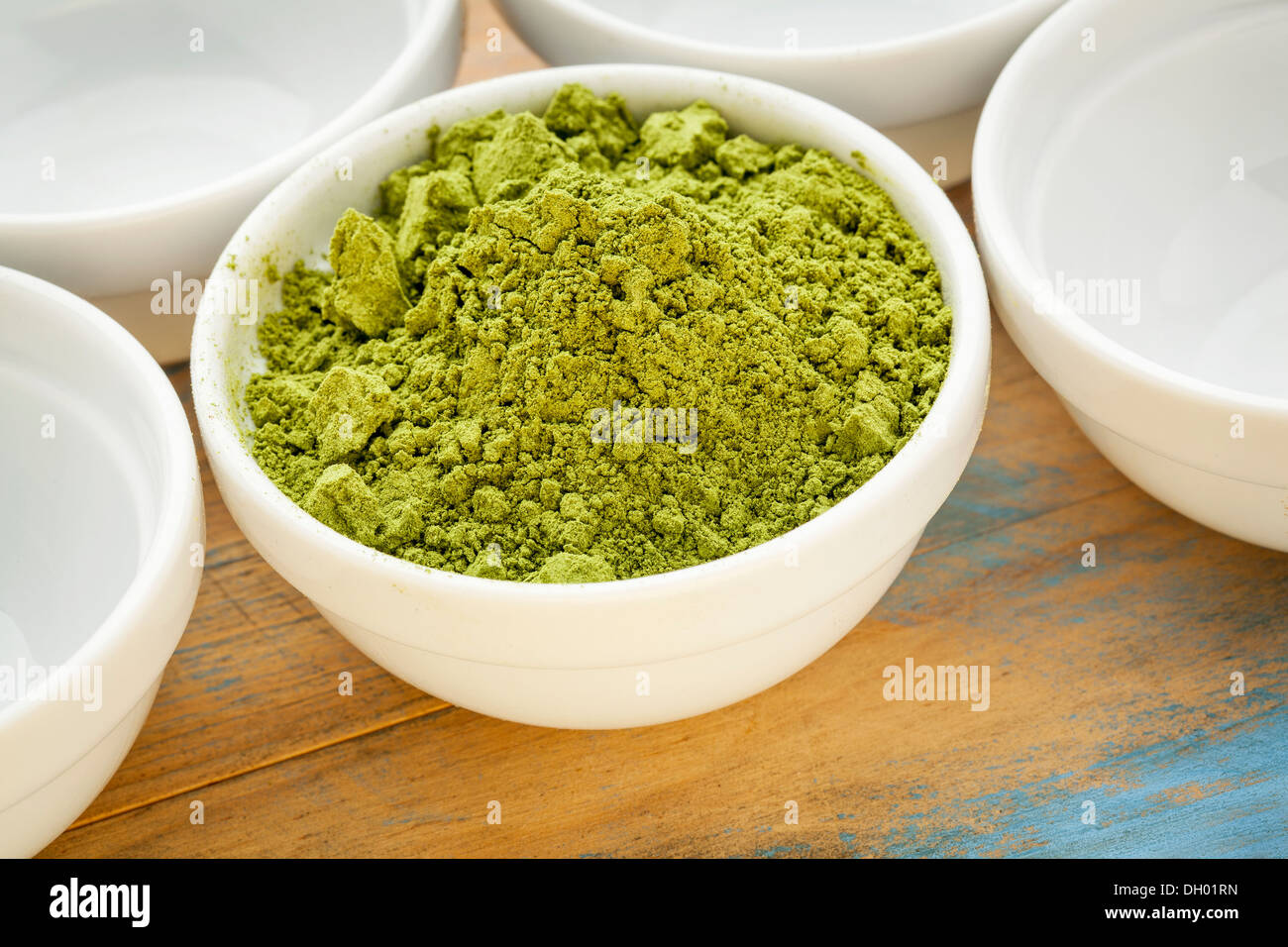 Poudre de feuilles de moringa dans un petit bol vide parmi les bols blanc Banque D'Images