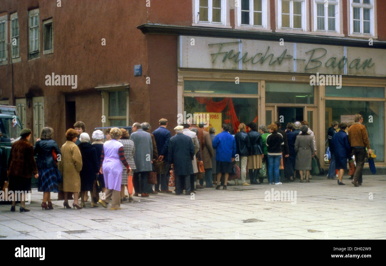 En face de la file d'une épicerie, d'un Frucht-Basar bazar de fruits, Erfurt, en avril 1985, dans la fenêtre s'affiche de propagande pour Banque D'Images