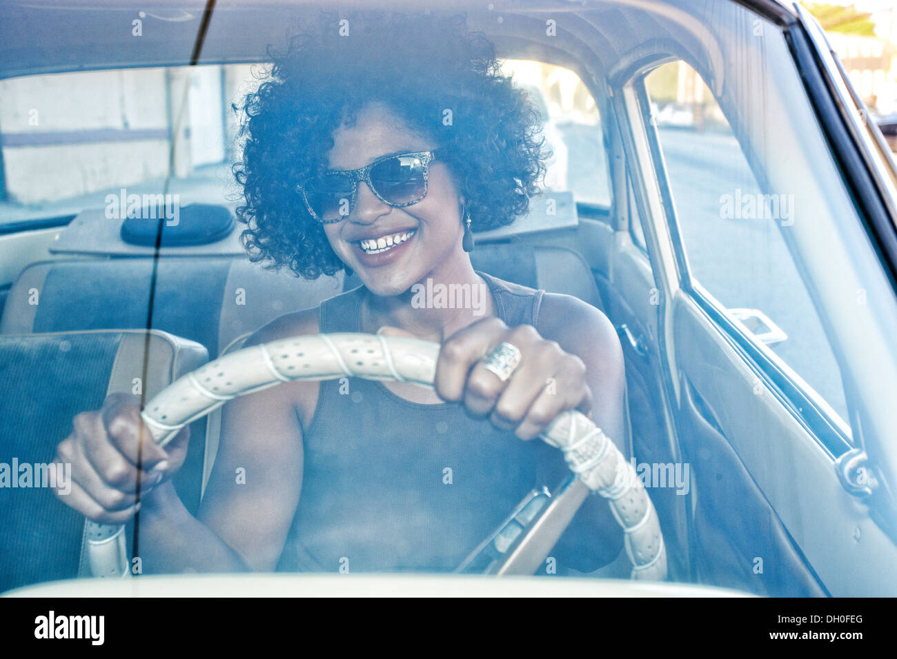 Mixed Race woman driving vintage car Banque D'Images