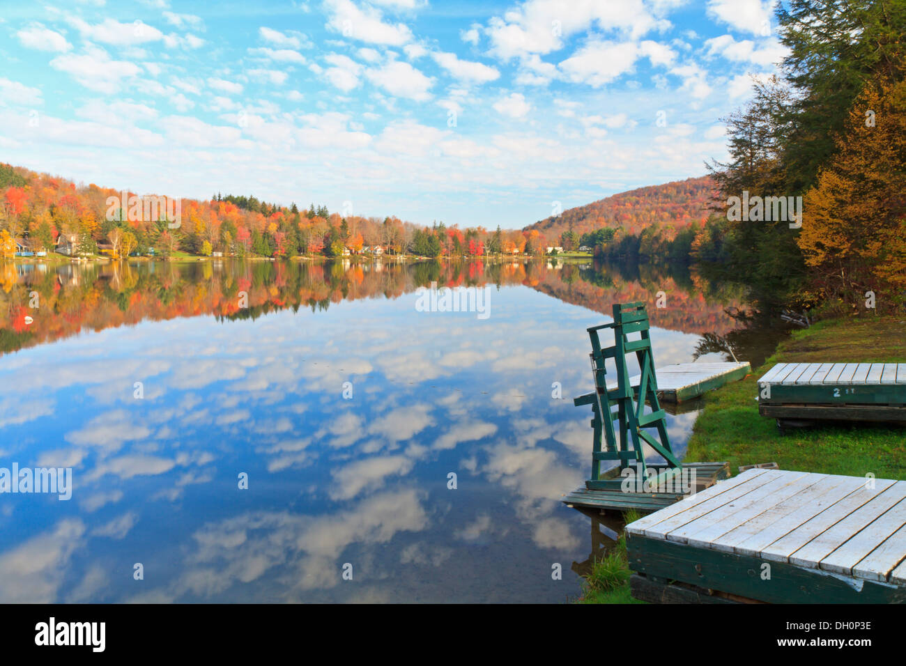 Un sauveteur présidence se trouve sur le bord du lac Perch dans les Catskills avec un ciel reflété à l'automne à New York Banque D'Images