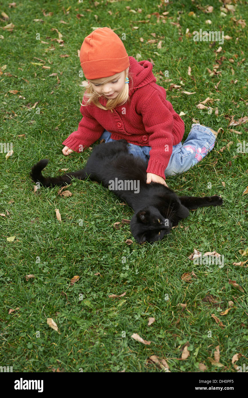 Fille blonde avec cat in garden Banque D'Images