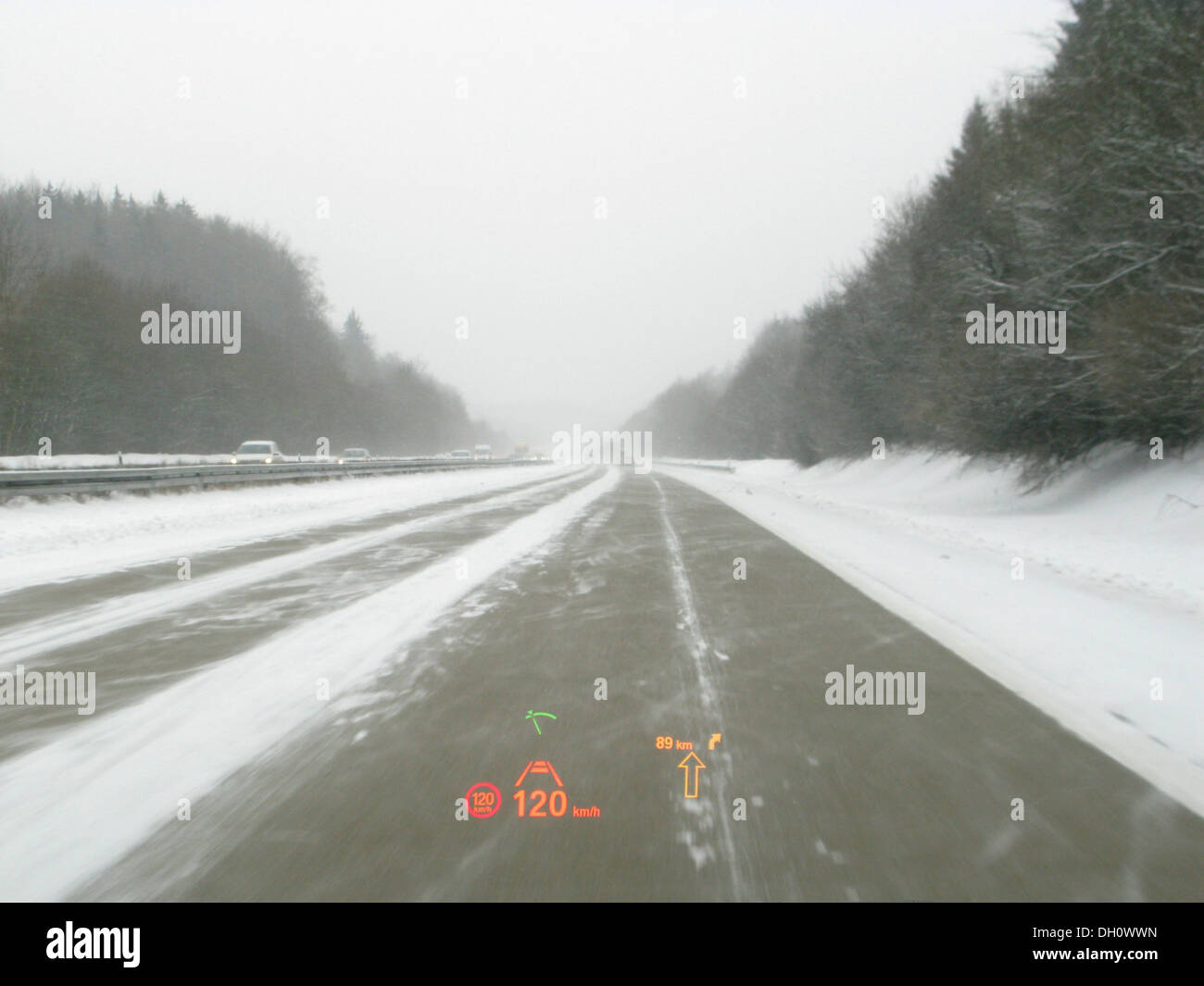 La conduite sur l'autoroute avec une BMW série 5 en cas de mauvaises conditions météorologiques, afficheur tête haute, signe de la circulation et des radars de distance Banque D'Images