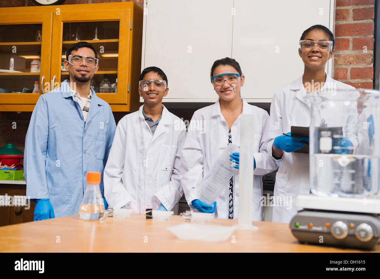 Enseignant et élèves smiling in science lab Banque D'Images