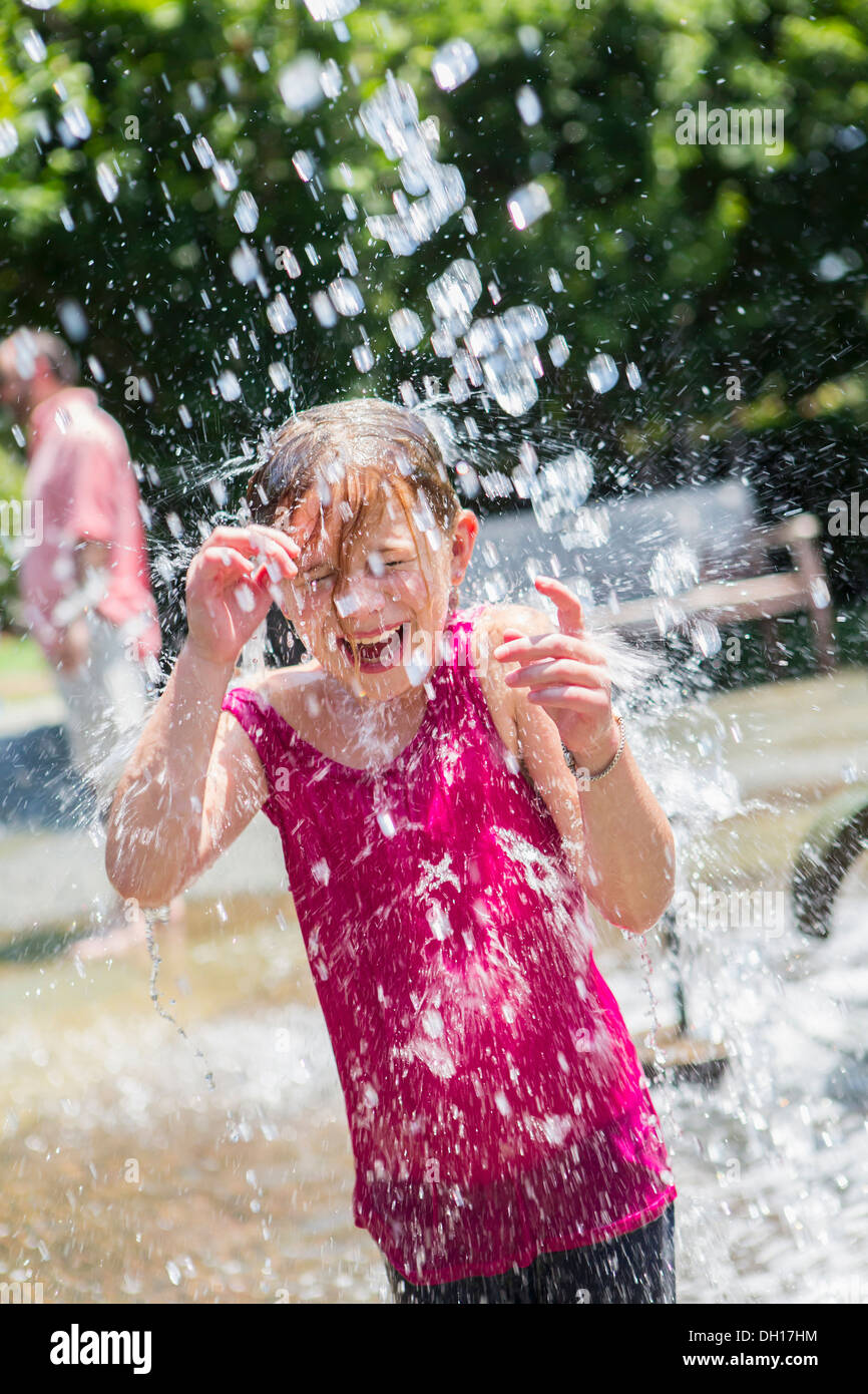 Caucasian girl playing in fountain Banque D'Images