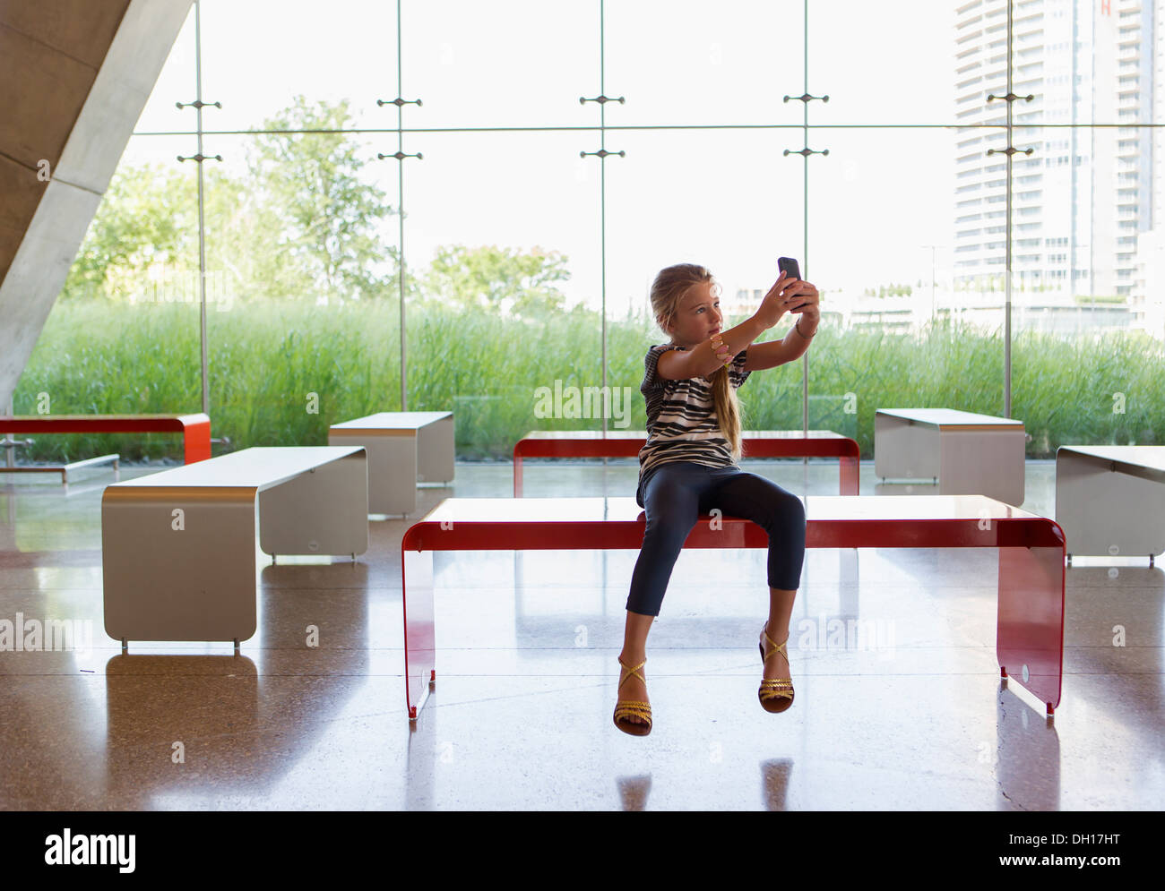 Caucasian girl taking self-portrait in lobby Banque D'Images