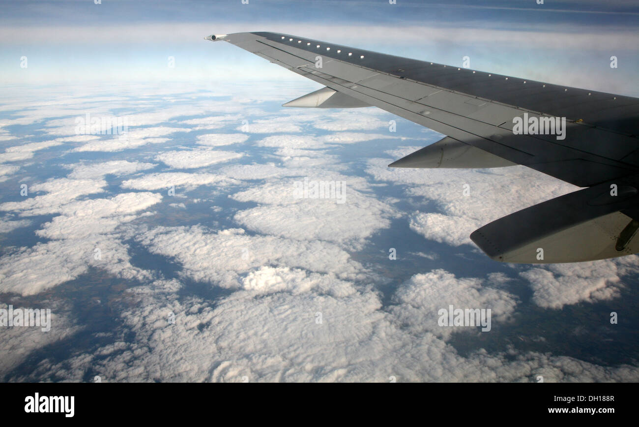 Regardant par la fenêtre de l'avion à l'escadre et les nuages ci-dessous Banque D'Images