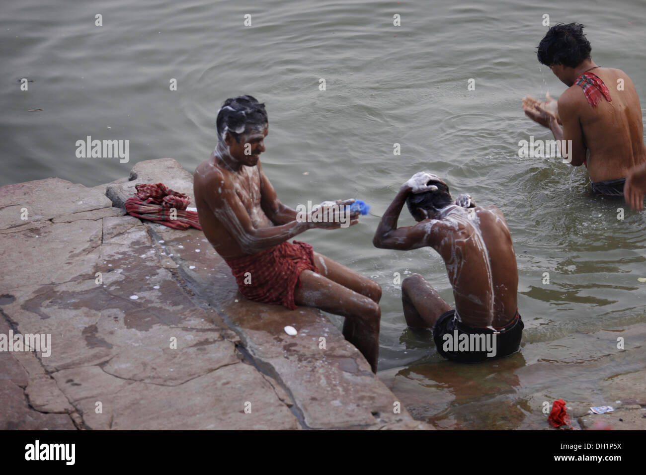 Trois hommes echelle Ganga Gange Varanasi dans l'Uttar Pradesh, Inde Banque D'Images