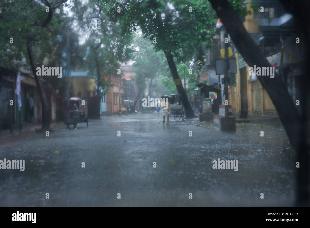 Man Walking street pluie pluie de mousson dans l'ouest du Bengale Calcutta Inde Asie Banque D'Images