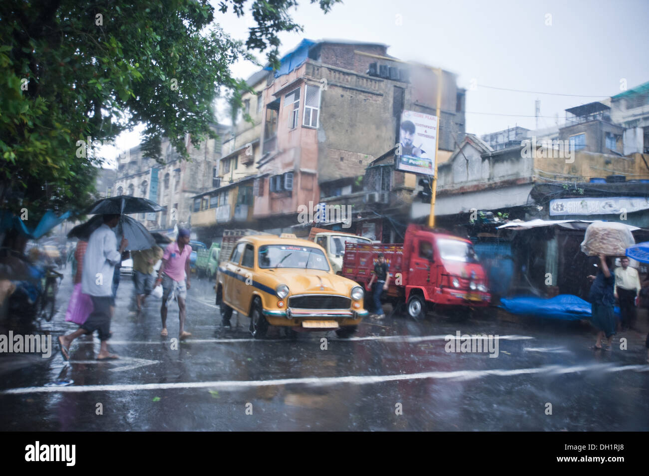 L'ambassadeur rouge jaune taxi camion personnes route de mousson en Asie Inde Kolkata Banque D'Images
