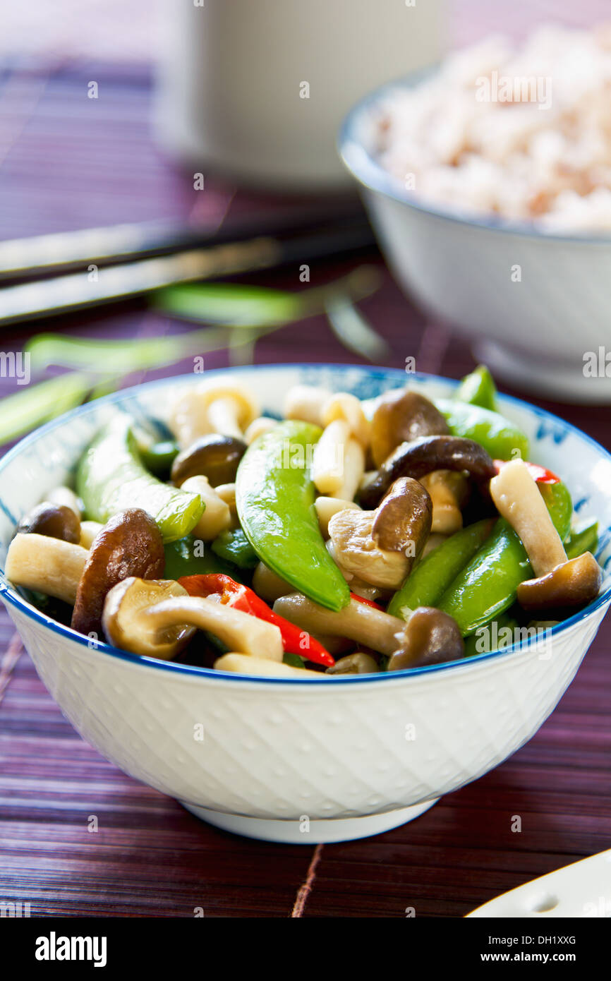 Pois frits brassé avec champignons avec la sauce aux huîtres par le riz brun Banque D'Images