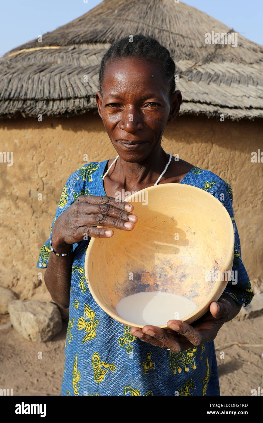 Une femme Peul présentant calebasse avec du lait frais, Burkina Faso Banque D'Images