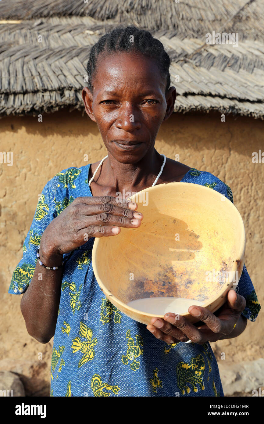 Une femme Peul présentant calebasse avec du lait frais, Burkina Faso Banque D'Images