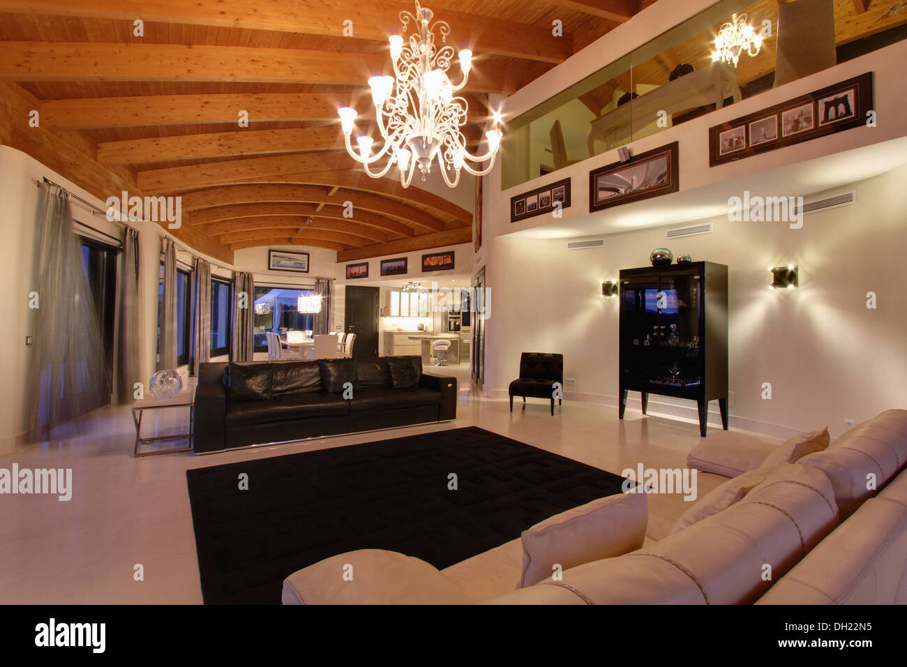 Le lustre d'un plafond aux poutres apparentes en espagnol moderne grand  salon avec canapés en cuir noir et blanc et noir sur blanc marbre tapis  Photo Stock - Alamy