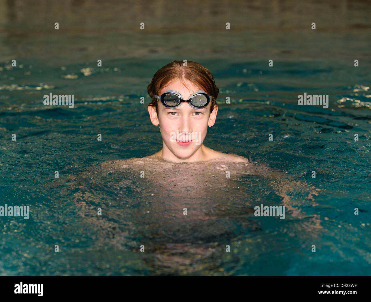 Garçon, nageur, 12 ou 13 ans, avec des lunettes de natation dans une piscine Banque D'Images