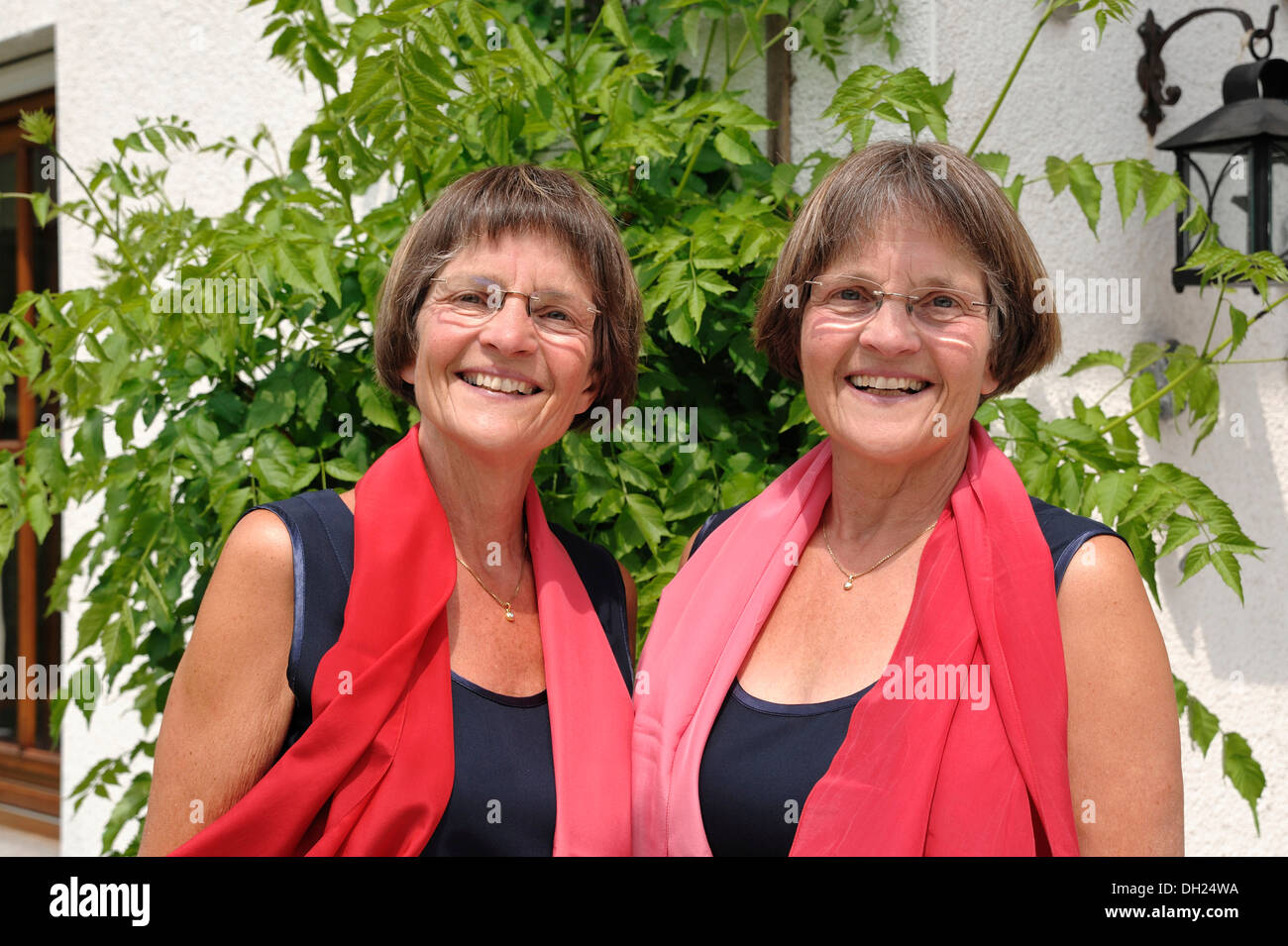 Deux sœurs jumelles rafraîchissante, habillés de la même façon, et portant des foulards rouges, portrait Banque D'Images