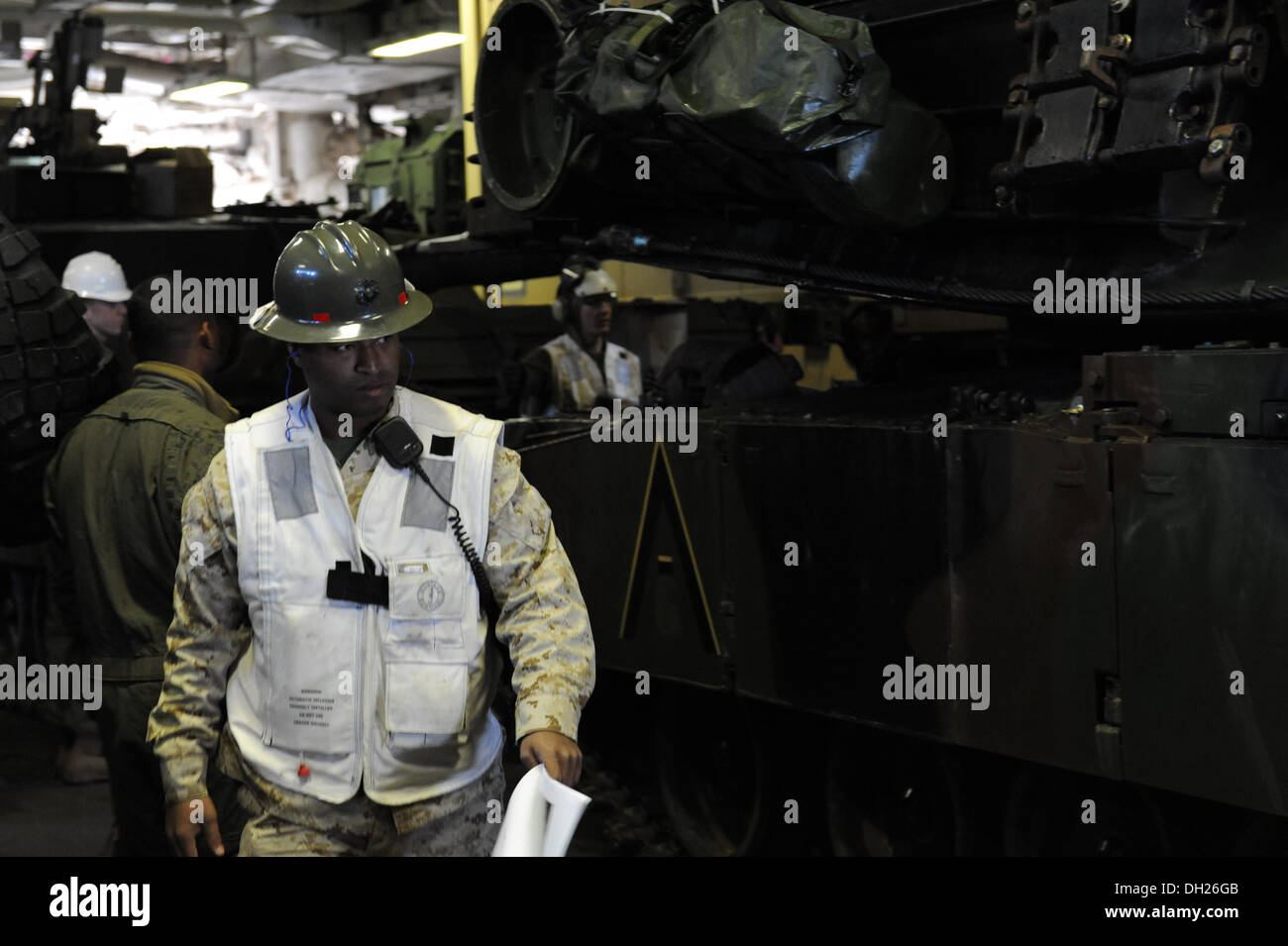 -Le sergent d'artillerie. Charles Gill, originaire de Pensacola, Floride, supervise les marins et soldats du déchargement d'un M1A1 char de combat principal d'un Banque D'Images