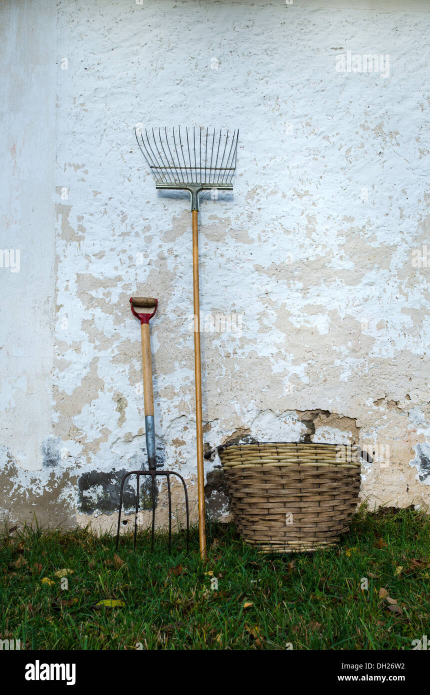 Vieux outils de jardin à un mur. Banque D'Images
